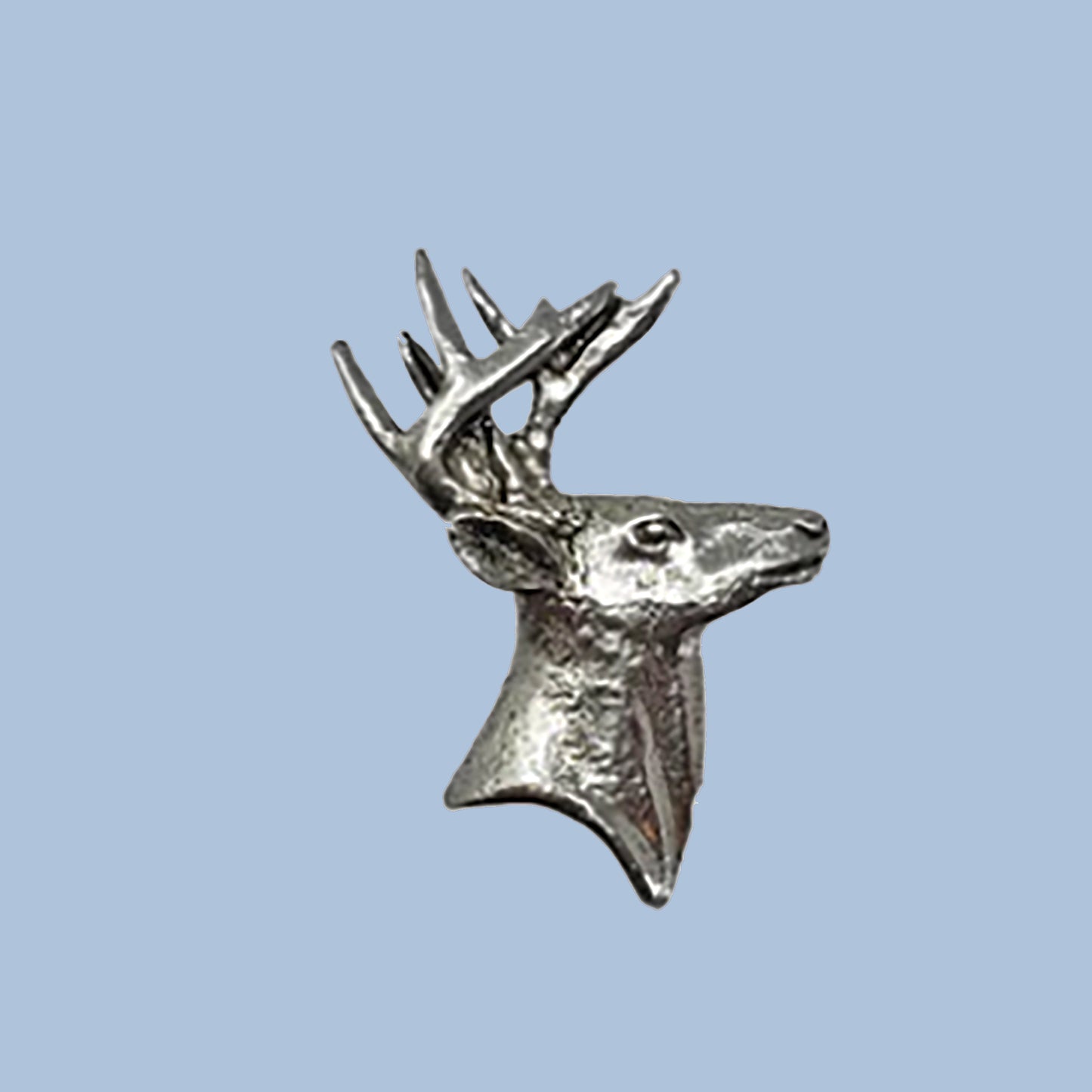 pewter deer head sculpture on a light blue background