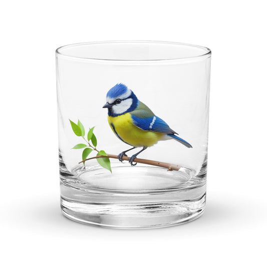 blue tit on a branch on a glass whisky tumbler
